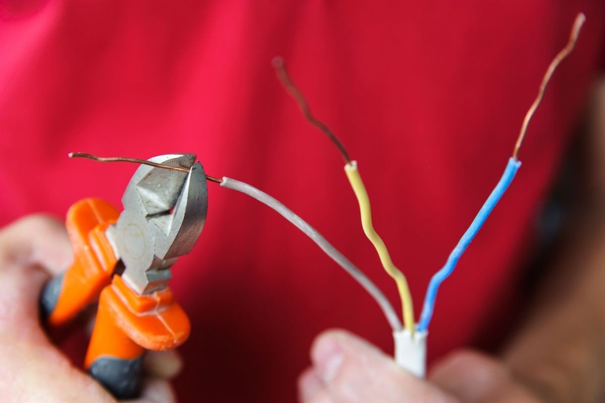 cortando fios para instalação de chuveiro elétrico