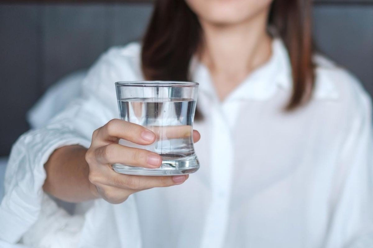 mulher segurando copo com água filtrada