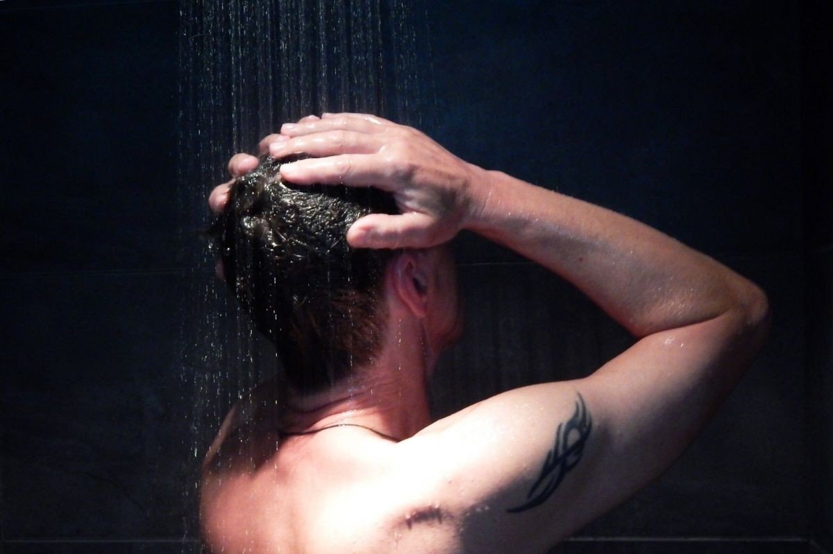 no banho com chuveiro elétrico lavando os cabelos