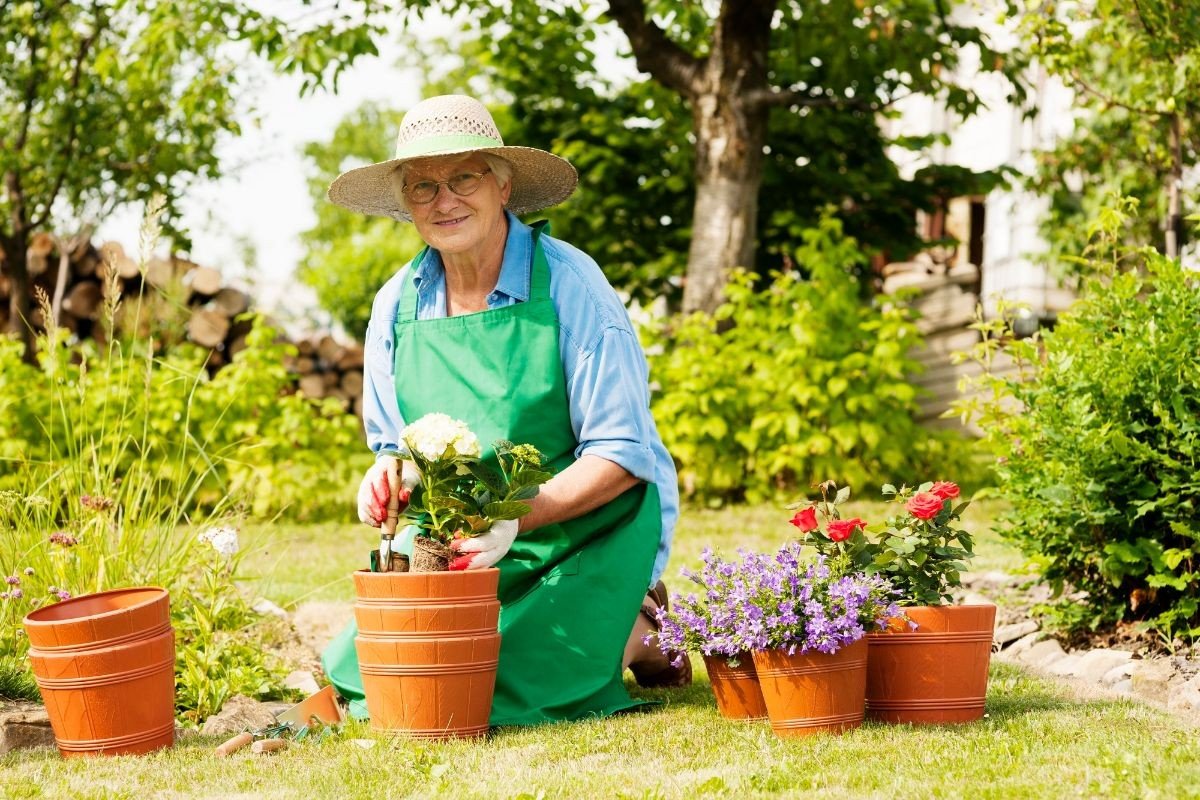 mulher preparando vasos de flor com alguns itens de jardinagem