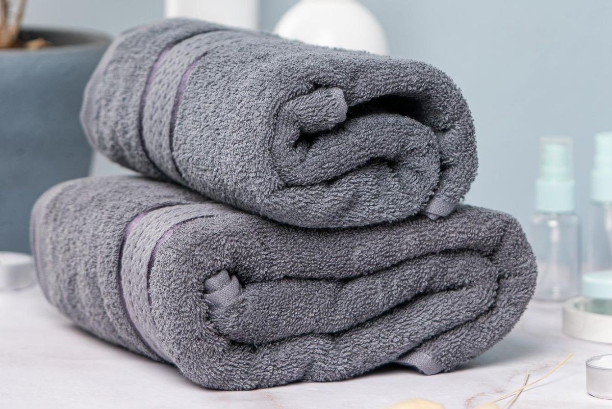 toalhas escuras em cima de balcao de banheiro